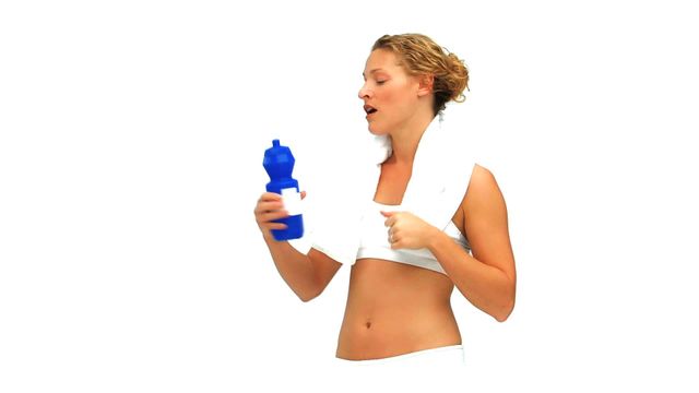 This video shows a curly haired woman hydrating with water after an intense workout. Ideal for content on fitness, hydration, sports routines, and healthy living. Suitable for blogs, fitness websites, and wellness advertisements.