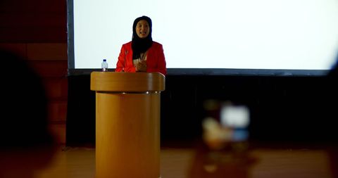 Confident Businesswoman Wearing Hijab Delivering Speech at Podium