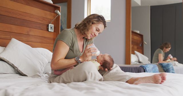 Image of happy caucasian mother feeding newborn baby with bottle on bed. motherhood, parental love and taking care of newborn baby concept digitally generated image.