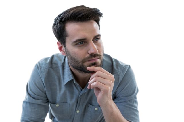 Thoughtful man with hand on chin against white background