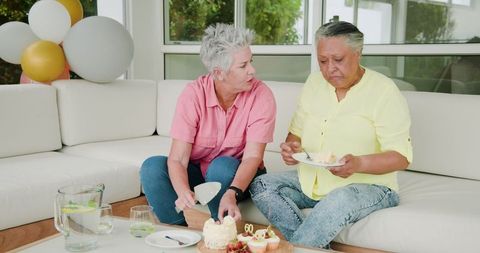Senior Lesbian Couple Celebrating Birthday with Cake and Conversation