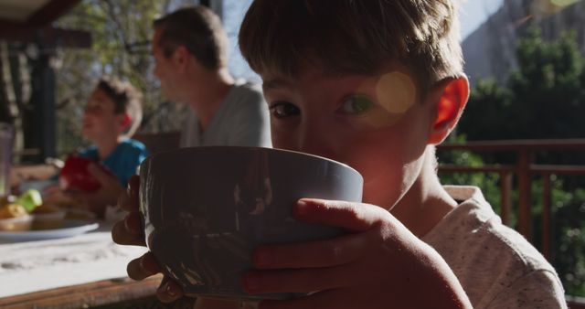 Boy Drinking from Bowl in Morning Sunlight - Download Free Stock Images Pikwizard.com