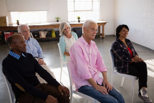 Attentive senior people sitting on chair in art class