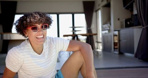 Stylish man relaxing in modern home interior with sunglasses