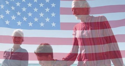 Senior couple and grandson enjoying patriotic beach day with american flag overlay