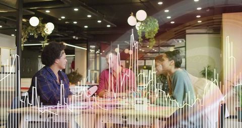 Multi-Ethnic Team Discussing Data Trends in Modern Office Environment