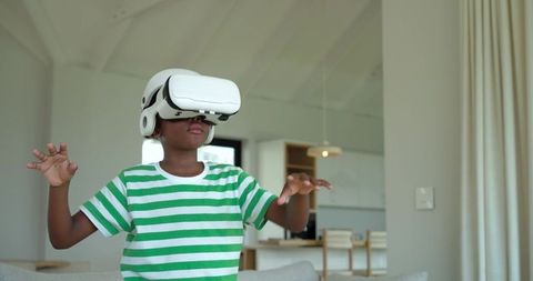 African American Boy Exploring Virtual Reality in Modern Living Room with White VR Headset