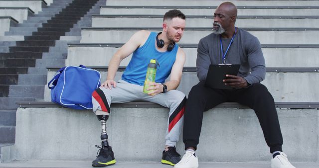 Athlete with Prosthetic Leg Listening to Coach in Stadium - Download Free Stock Images Pikwizard.com