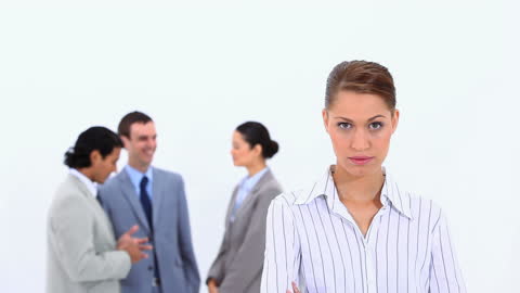 Focused Businesswoman with Conversing Colleagues in Background