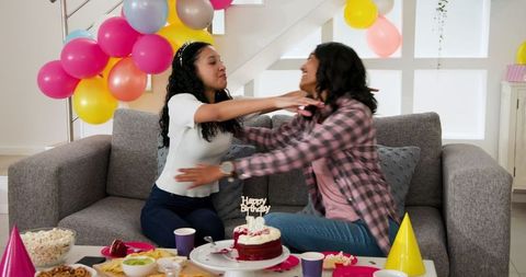 Women Celebrating Birthday with Colorful Decorations in Living Room