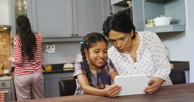 Grandmother and granddaughter bonding over tablet in kitchen - Download Free Stock Images Pikwizard.com