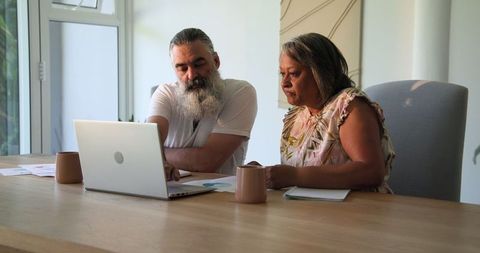 Senior Couple Using Laptop Planning Retirement at Home with Coffee