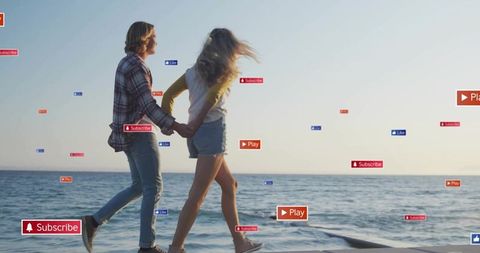 Young couple walking on pier with social media subscribe play like overlays at golden hour