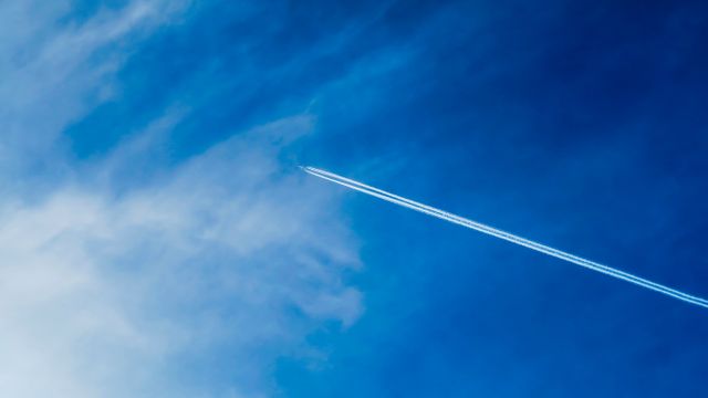 Airplane flying across blue sky with vapor trail - Download Free Stock Photos Pikwizard.com