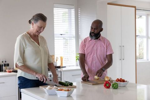 Diverse Senior Couple Prepping Vegetables in Modern Kitchen