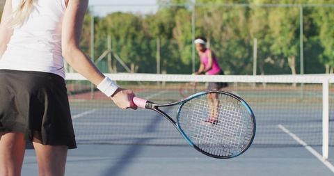Female Tennis Player Serving on Outdoor Hard Court with Racket Ready for Return