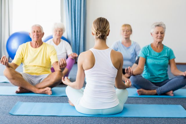 Yoga Instructor Leading Senior Class in Meditation - Download Free Stock Photos Pikwizard.com