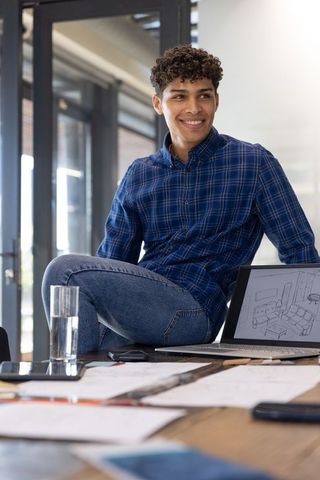 Young Professional Reviewing Sketches In Modern Office