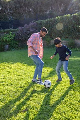 Father and son bonding through backyard soccer game