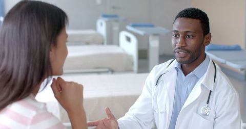 Doctor consulting with patient in hospital ward