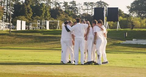 Cricket team huddling in unity on the field