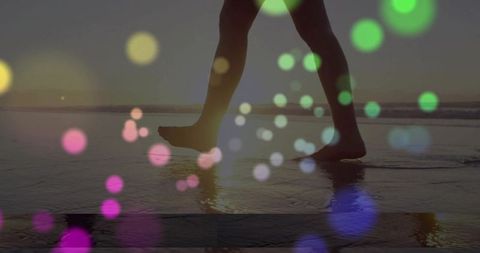 Woman Walking on Wet Sand with Bokeh Effect at Twilight