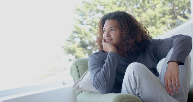 Relaxed Young Man Sitting on Comfortable Green Sofa Contemplating - Download Free Stock Images Pikwizard.com