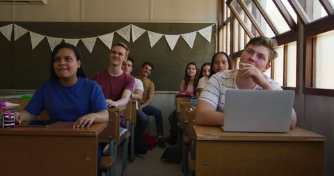 Diverse teenage students attentive in classroom learning environment