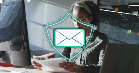 Professional reviewing documents with glowing email shield overlay for cyber security