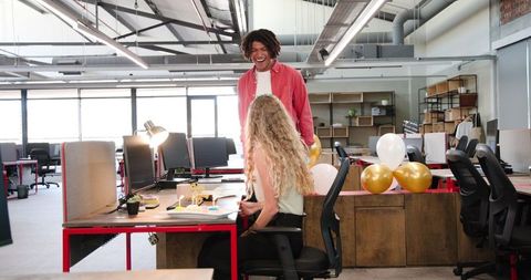 Colleagues Celebrating Success in Modern Office with Balloons