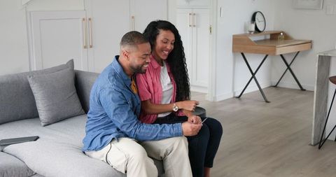 Couple celebrating pregnancy viewing ultrasound scan at home