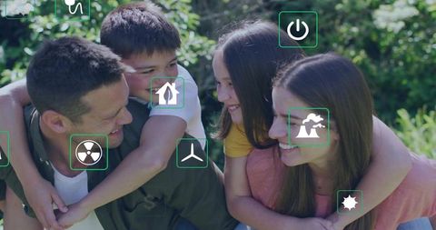 Smiling family playing piggyback on sunny backyard lawn with green energy icons overlay