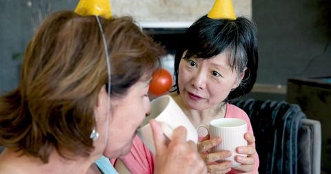 Senior women celebrating birthday with coffee at home gathering