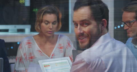 Business Team Analyzing Data with Financial Overlay Graphics