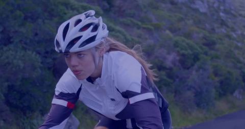 Determined Female Cyclist Riding on Winding Country Road