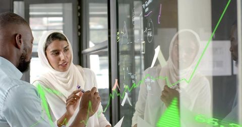Diverse Team Analyzing Data on Glass Board in Modern Office