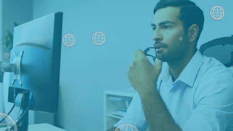 Businessman Strategizing at Desk with Digital Icons Overlay