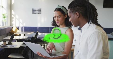 Collaborative Team Analyzing Hologram Display with Laptop in Modern Workspace
