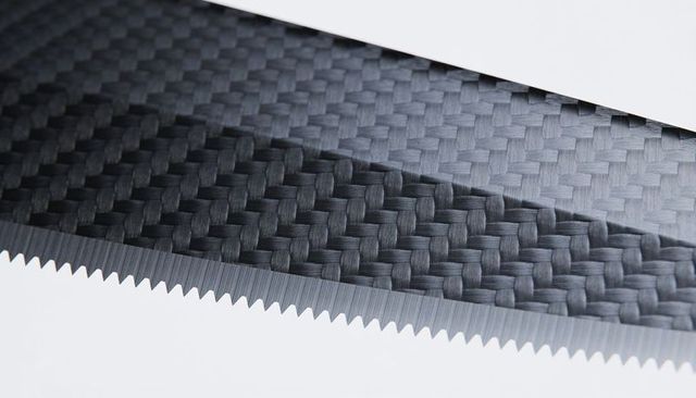 Macro serrated blade featuring carbon fiber twill surface and micro-serrated brushed edge