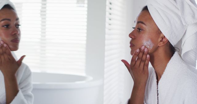 Woman Applying Face Cream While Looking in Mirror - Download Free Stock Images Pikwizard.com