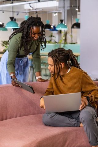 African American Colleagues Collaborating in Coworking Lounge with Laptop and Tablet