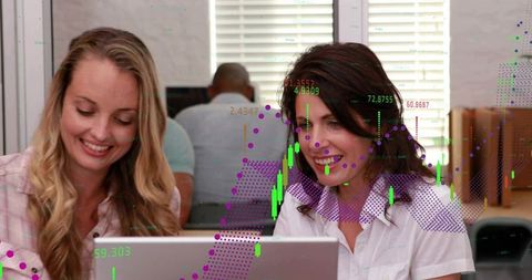 Coworkers collaborating on laptop with stock charts overlay and business analytics