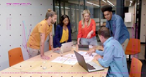 Diverse Team Collaborating Around Conference Table Pointing at Laptops and Strategy Charts