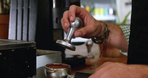 Barista tamping portafilter with precision in artisan cafe