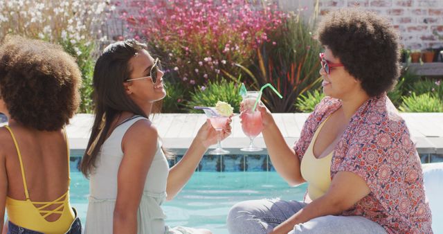 Group of friends with afro hair enjoying summer drinks by pool, wearing sunglasses. Ideal for promoting summer lifestyle, social gatherings, outdoor leisure, and warm-weather activities. Perfect for use in travel brochures, social media posts, and advertisements related to summer vacations and poolside fun.