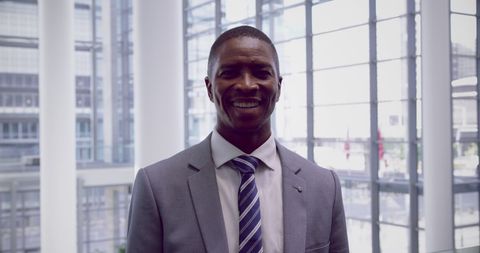Confident Businessman Smiling in Contemporary Office Lobby