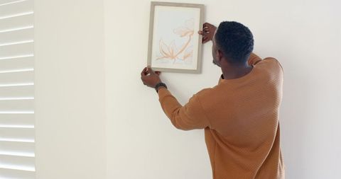 Man Hanging Wall Art in Modern Minimalist Home