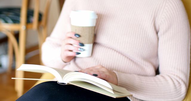 Person relaxing with a book and takeaway coffee cup at home - Download Free Stock Images Pikwizard.com