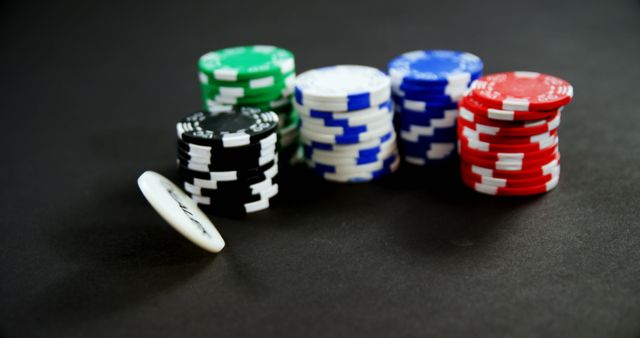 Colorful poker chips in stacks on black background typically used for gambling-themed designs, casino marketing materials, gaming tutorials, and betting guides.