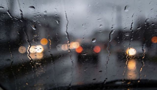 Rain-Streaked Windshield with Urban Traffic Bokeh at Dusk Moody Commuter Night Scene